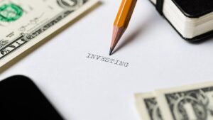 A pencil writing "investment" on a piece of paper