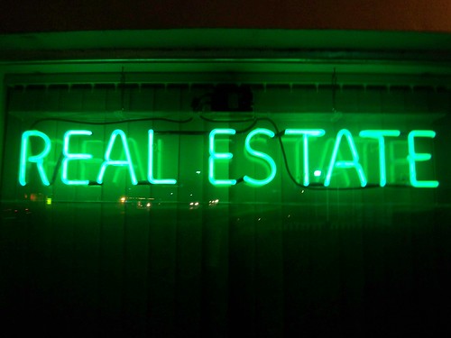 a neon sign with the word "real estate"