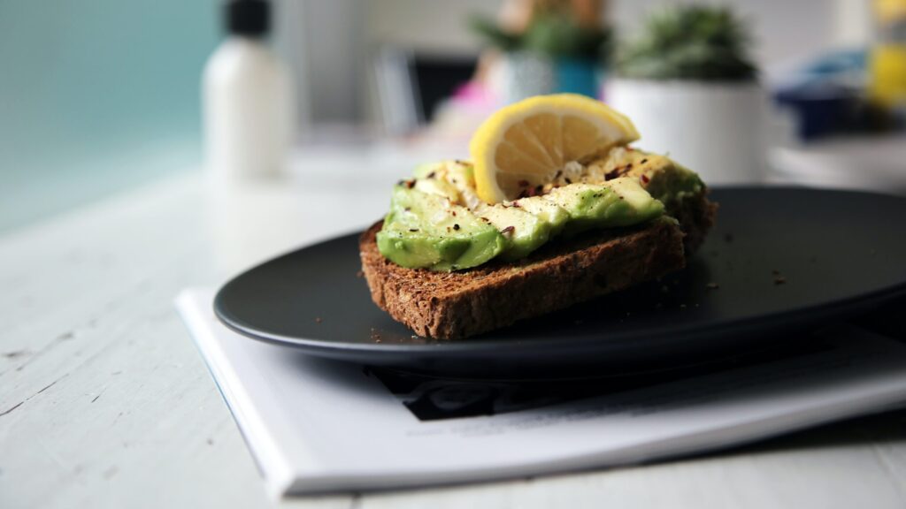 avocado toast on rye with a lemon wedge