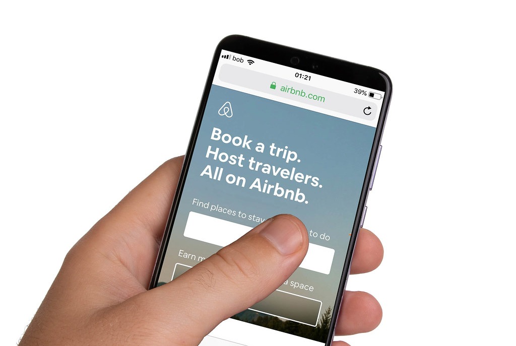 Male hands holding smartphone with an open Airbnb application