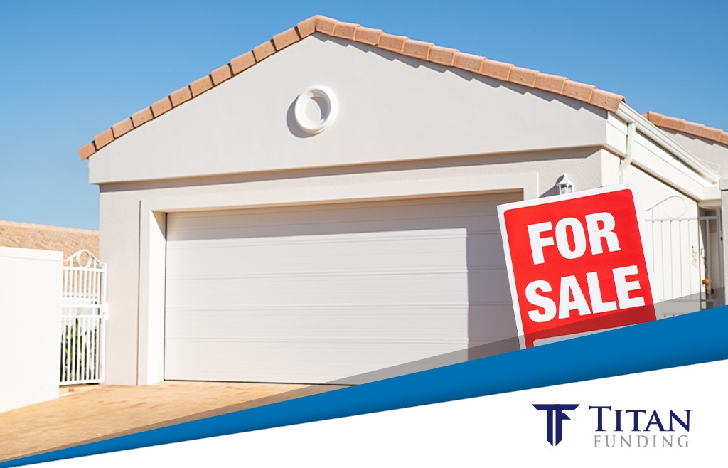 Beige house with a for sale sign outside of it.